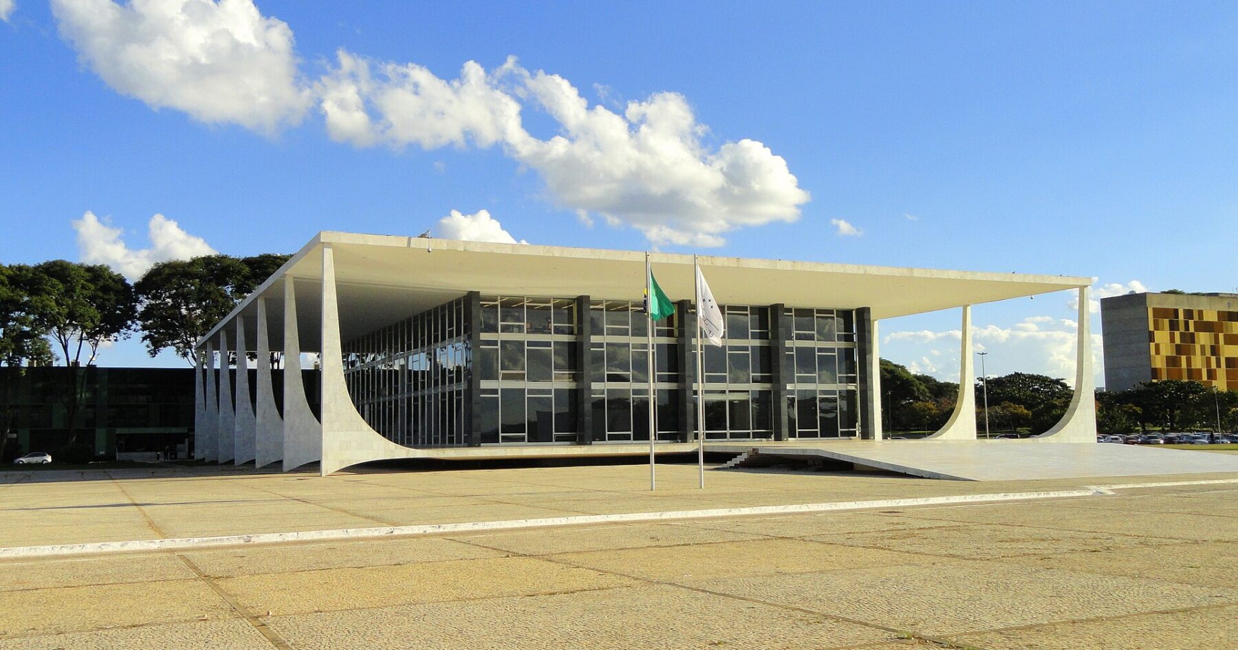 Modern court building with flags under blue sky