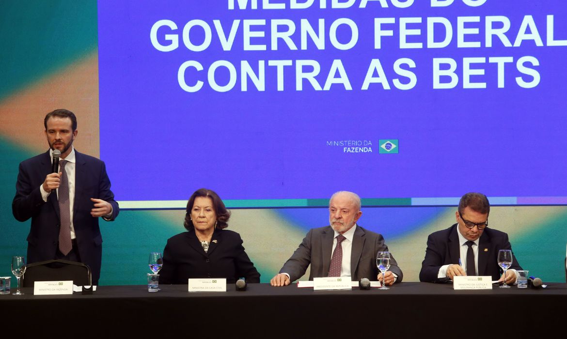 Brazil football clubs betting ban: Finance Minister Dario Durigan speaks beside President Lula under a screen reading Medidas do Governo Federal contra as Bets in São Paulo