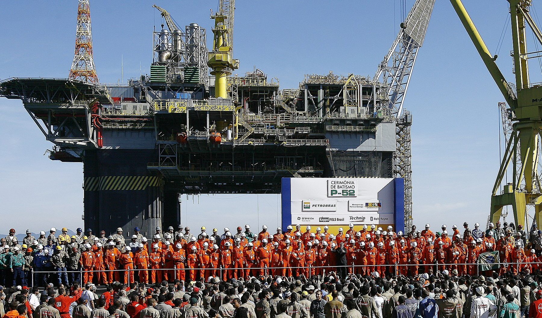 Petrobras P-52 oil platform at its naming ceremony in Angra dos Reis, with workers in orange overalls in front