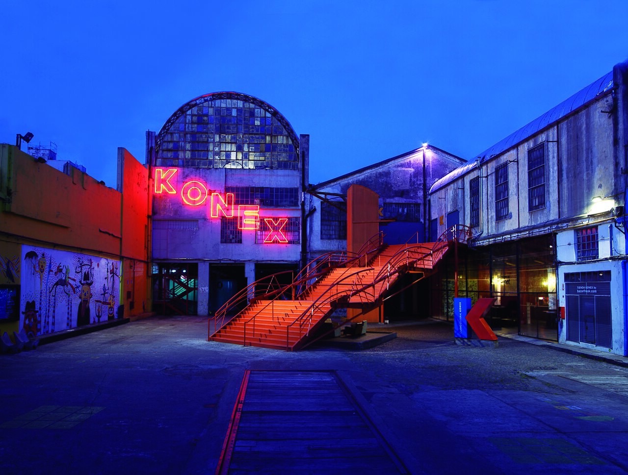 The illuminated neon Konex sign above the courtyard of Ciudad Cultural Konex in Buenos Aires at night, with an orange staircase leading up to the entrance.