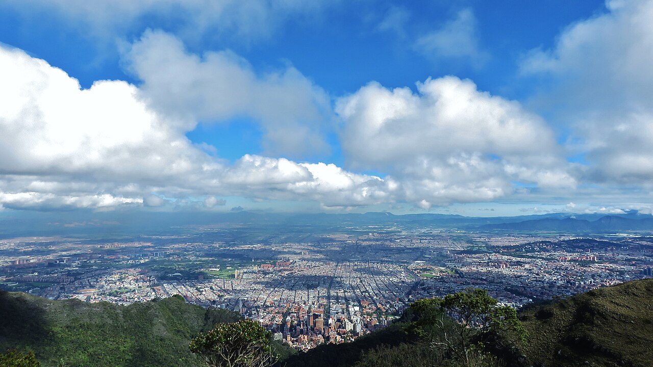 Colombia bonds: view over Bogotá from the eastern hills, with the city centre below a sky of white clouds