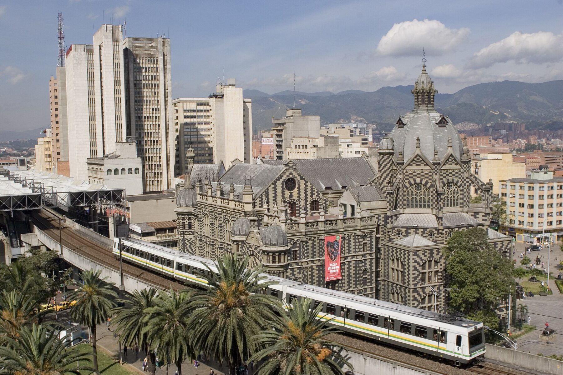 Metro de Medellín train passing the Palacio de la Cultura Colombia transport costs