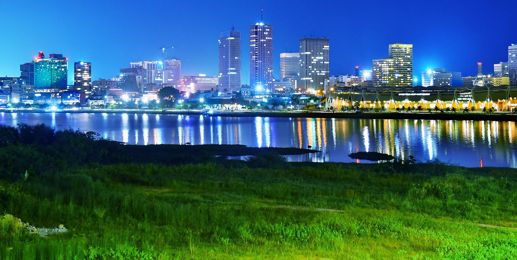 Côte d'Ivoire explained 2026 — the Plateau business district of Abidjan at night, seen across the Ébrié Lagoon