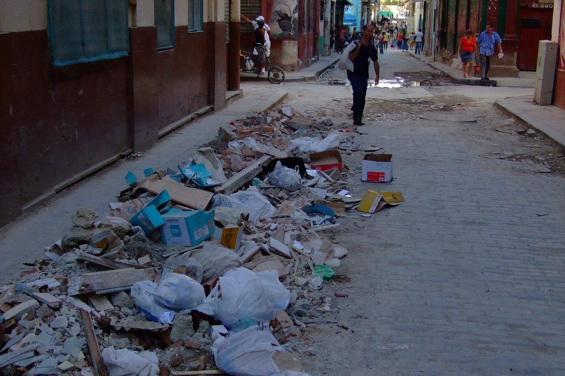A narrow street in Old Havana, Cuba, with rubbish piled at the roadside