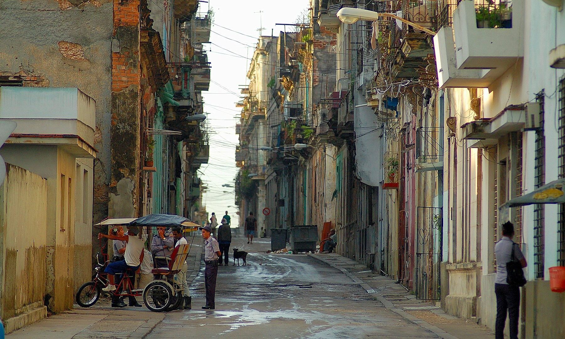 Cuba synthetic drug: people and a bicycle taxi on Lealtad street in Centro Habana, Havana, between run-down buildings