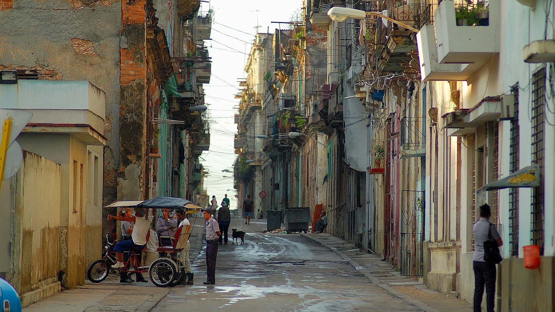 Cuba synthetic drug: people and a bicycle taxi on Lealtad street in Centro Habana, Havana, between run-down buildings