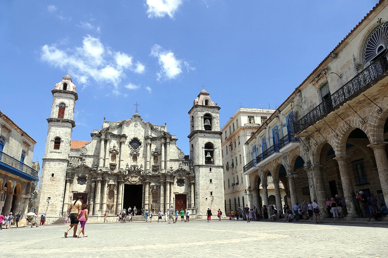 Cuba tourism: visitors crossing Plaza de la Catedral in Old Havana in front of the baroque cathedral
