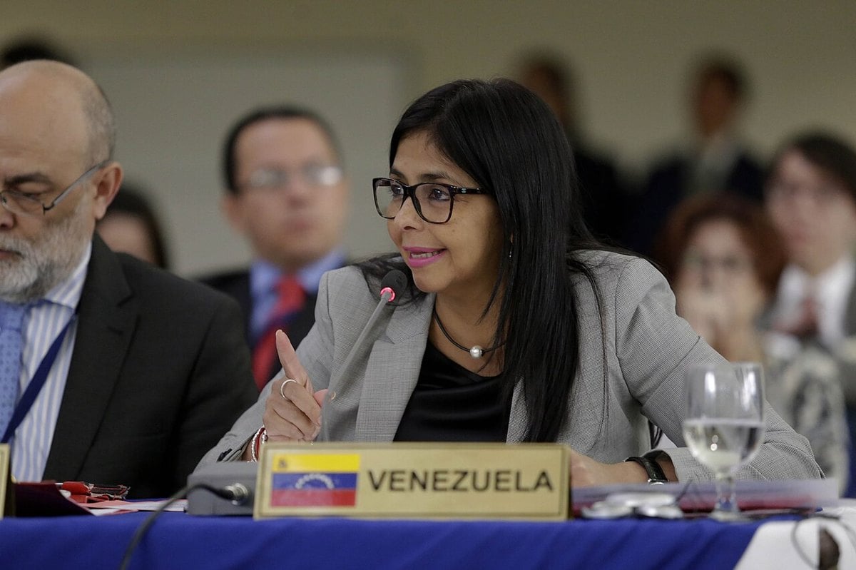 Delcy Rodriguez speaking behind a Venezuela name plate at a regional diplomatic meeting