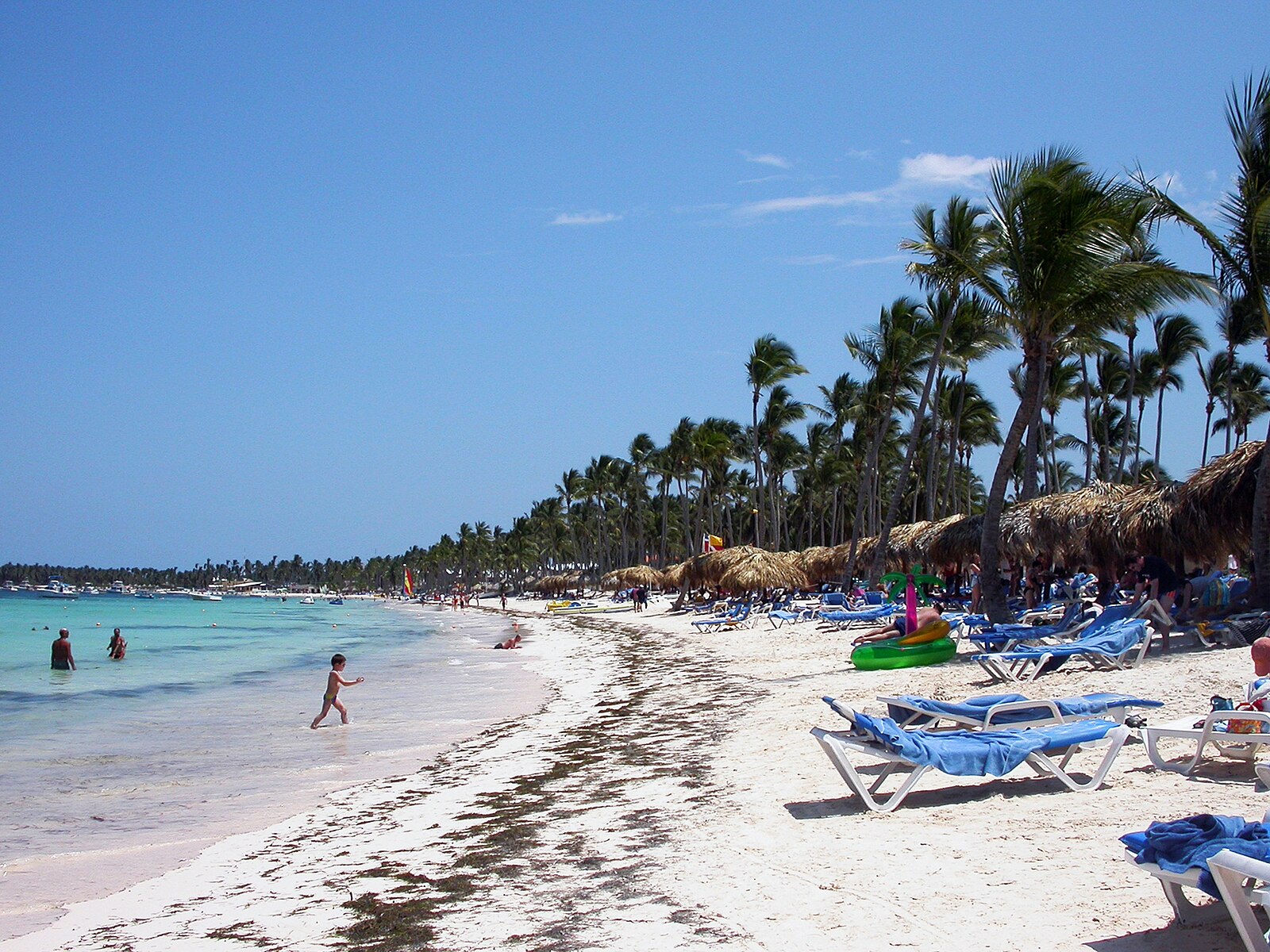 Dominican Republic tourism — sun loungers and thatched shades on a resort beach in Punta Cana