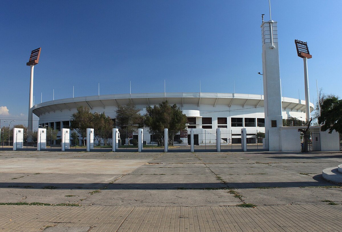 The white curved grandstand of the Estadio Nacional in Santiago seen from Avenida Grecia
