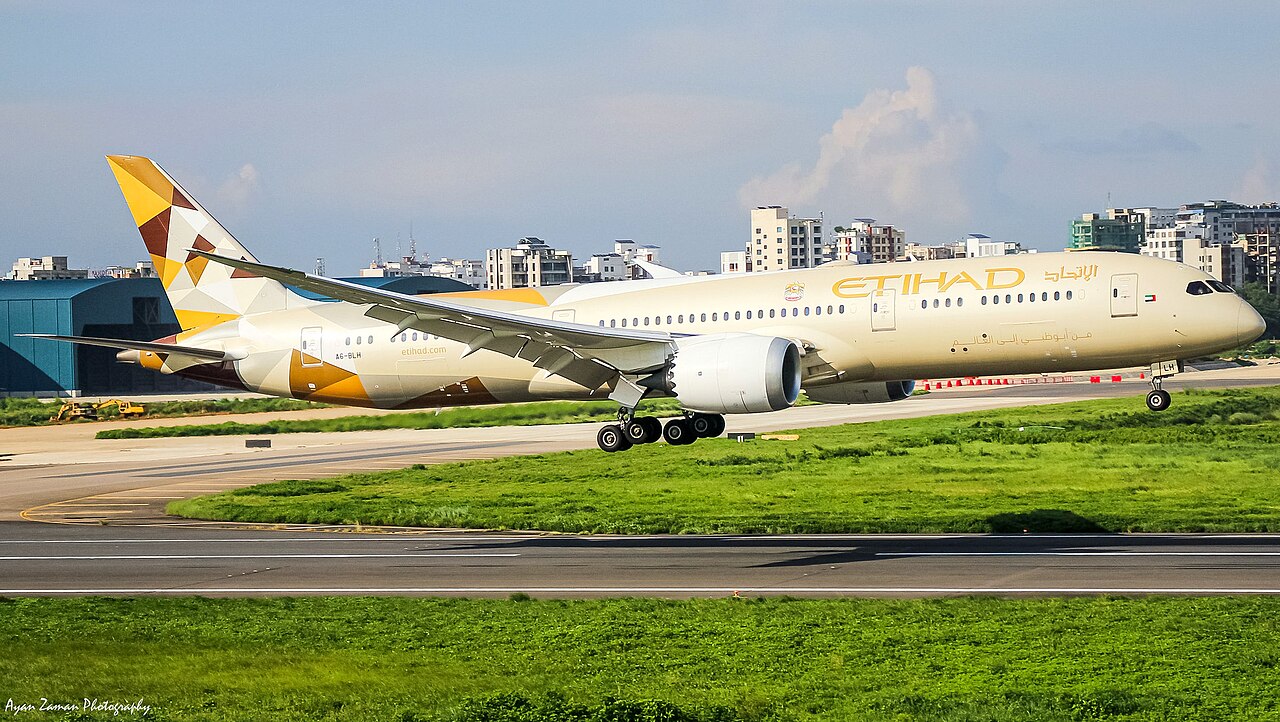 Etihad Airways Boeing 787-9 Dreamliner touching down, with the airline's gold and white tail livery visible