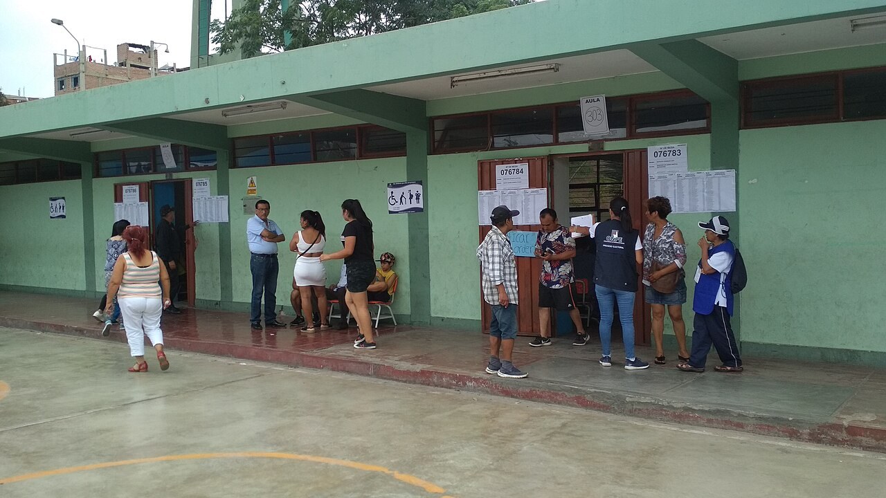 Voters wait outside classrooms used as polling stations at a school in Callao, Peru