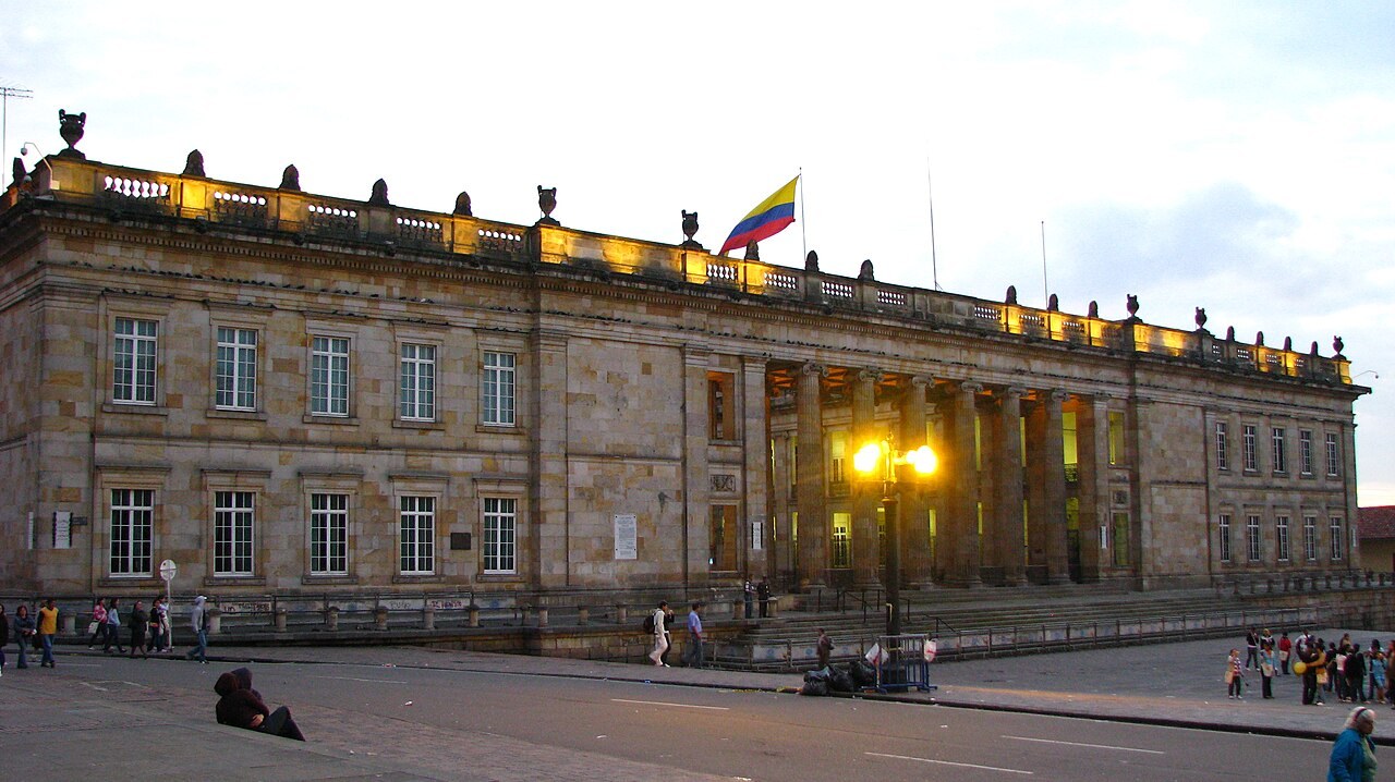 Colombia prison transfer - Facade of the Capitolio Nacional in Bogotá at dusk with the Colombian flag on the roof