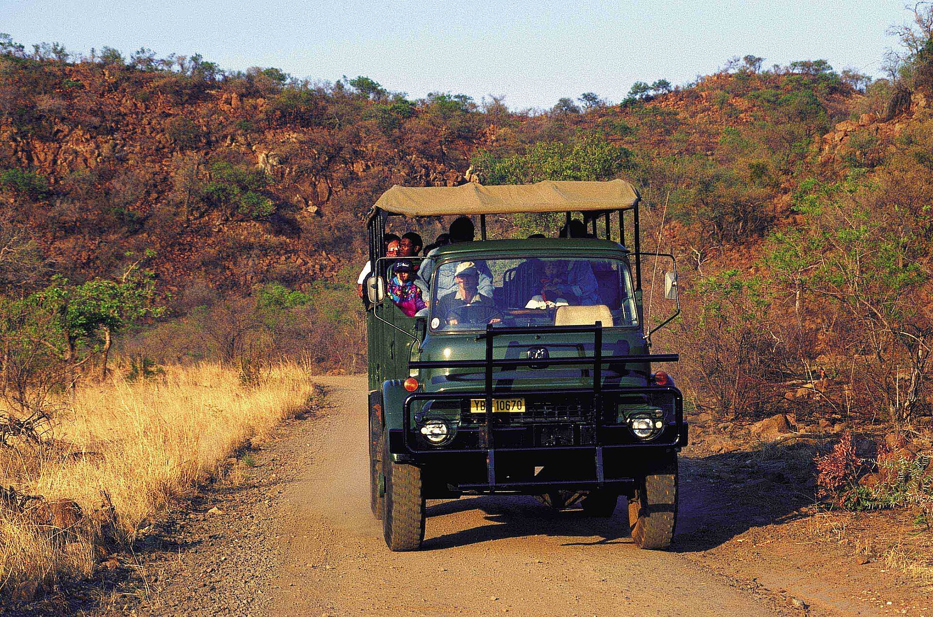 A safari vehicle on a dirt track in Pilanesberg National Park, South Africa