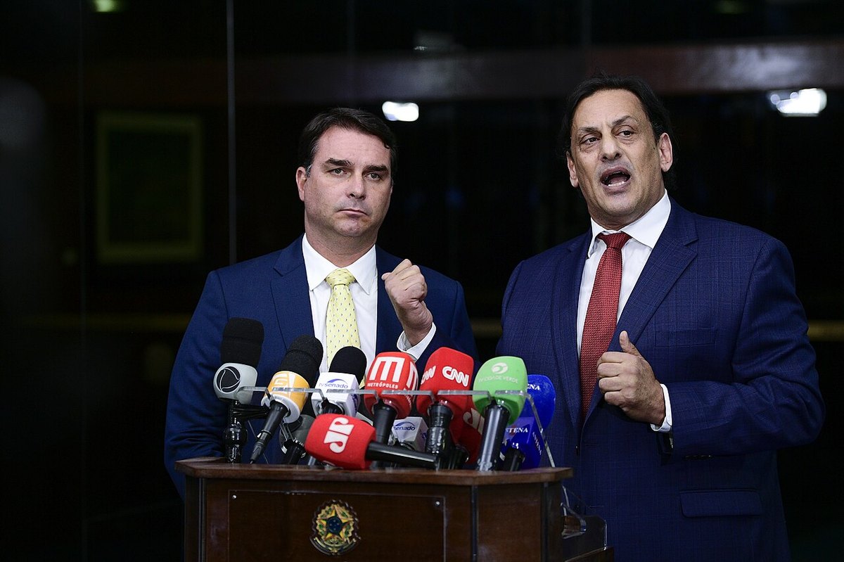 Flávio Bolsonaro and lawyer Frederick Wassef speaking to the press