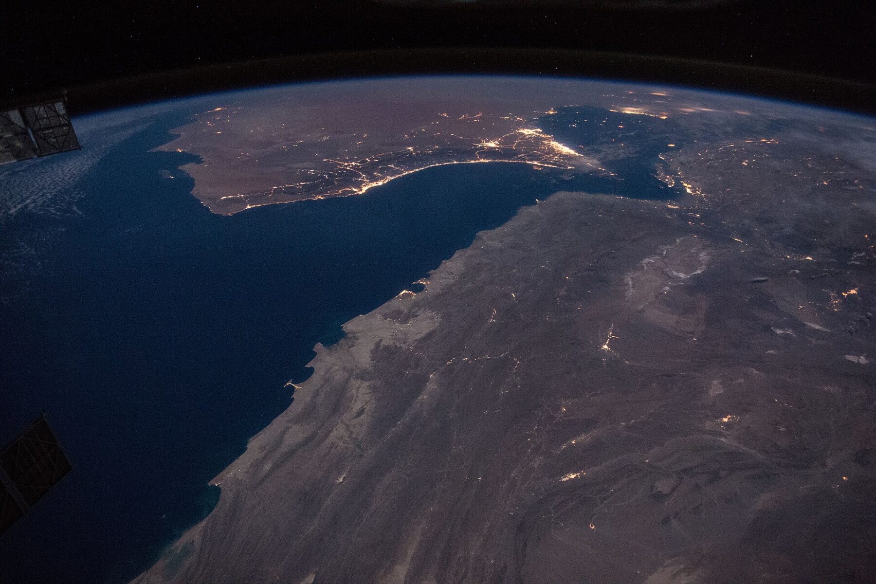 Night view from the International Space Station of the Strait of Hormuz and the Gulf of Oman, with the coastal cities of the United Arab Emirates and Oman lit up