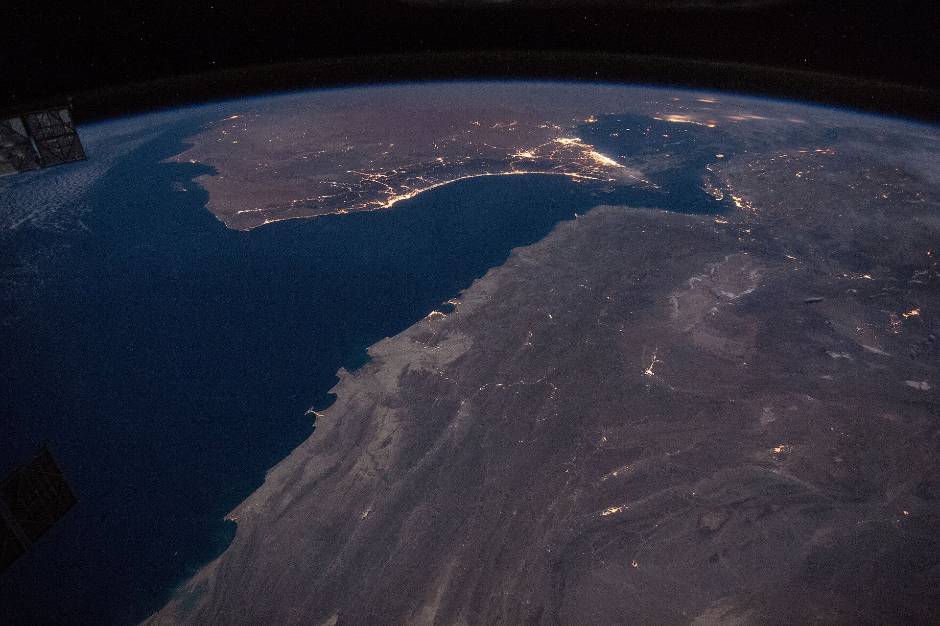 Night view from the International Space Station of the Strait of Hormuz and the Gulf of Oman, with the coastal cities of the United Arab Emirates and Oman lit up