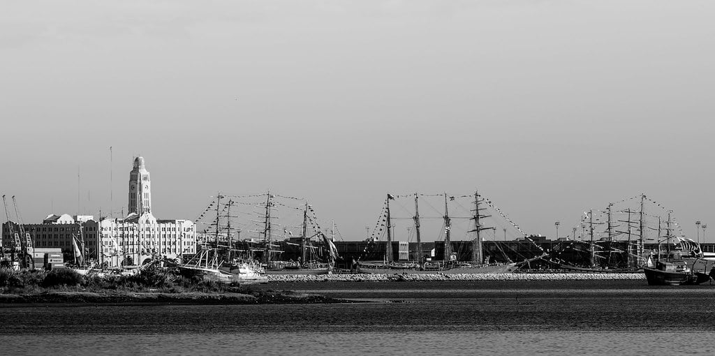Tall ships moored at the Port of Montevideo in a black-and-white photograph