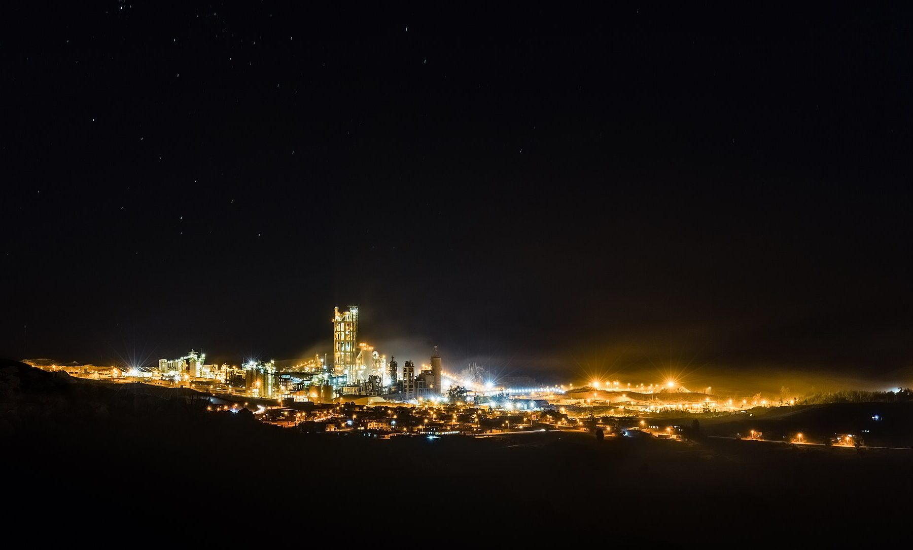 A cement plant lit up at night in Yura, Peru
