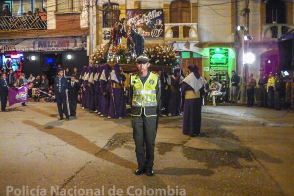 A Colombian police officer standing on duty during a street procession in Pamplona, Norte de Santander