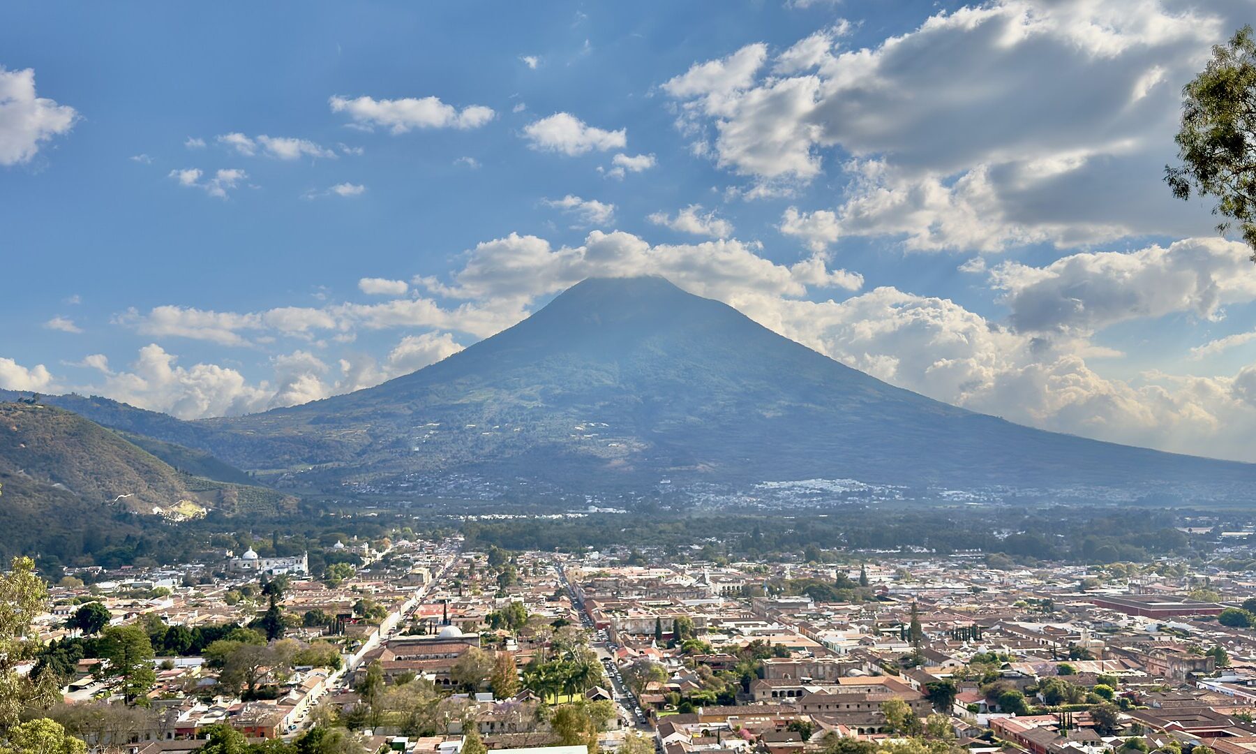 A colonial street in Antigua Guatemala with a volcano behind