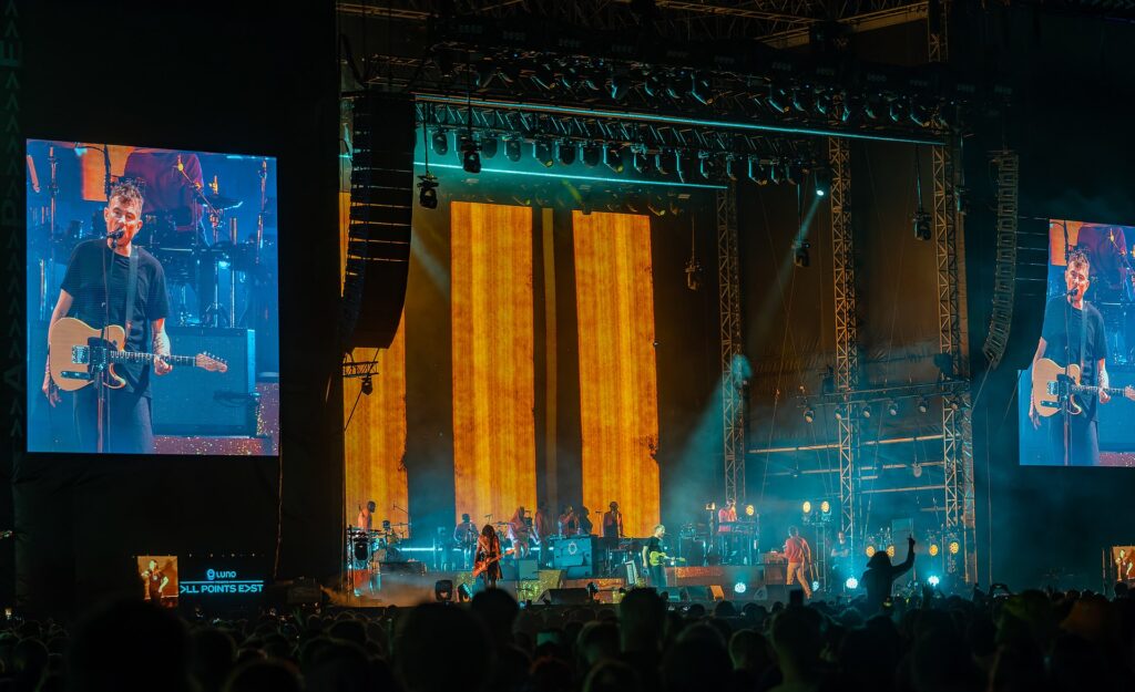 A band performing on a large stage at a concert.