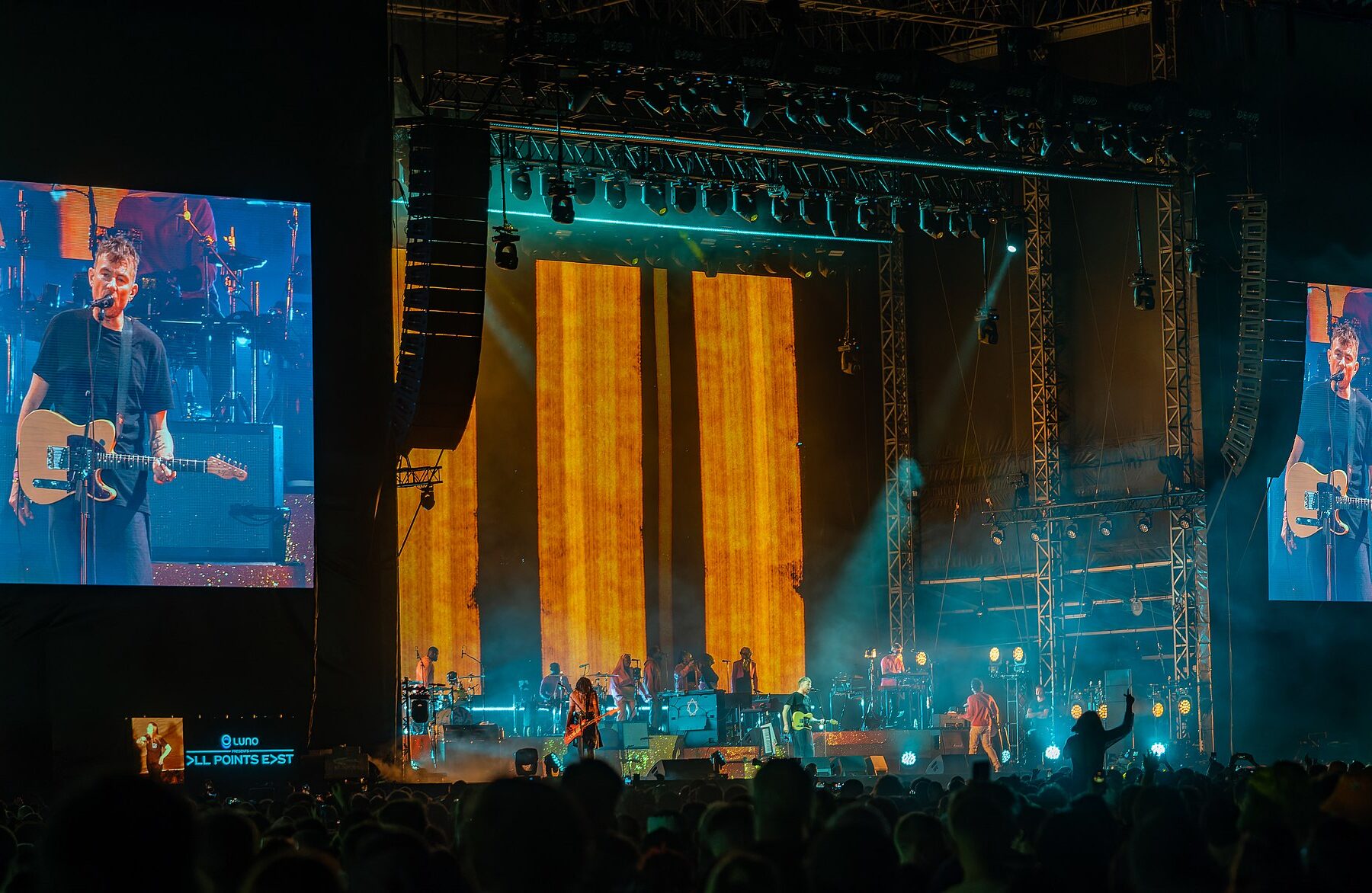 A band performing on a large stage at a concert.