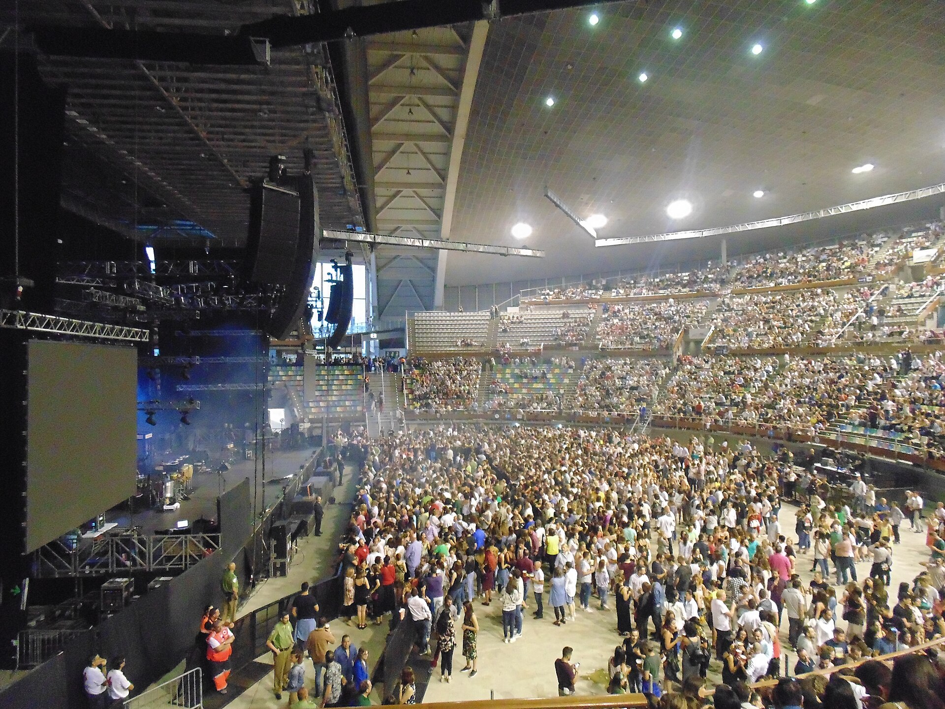 A large indoor arena crowd at a Juan Luis Guerra concert