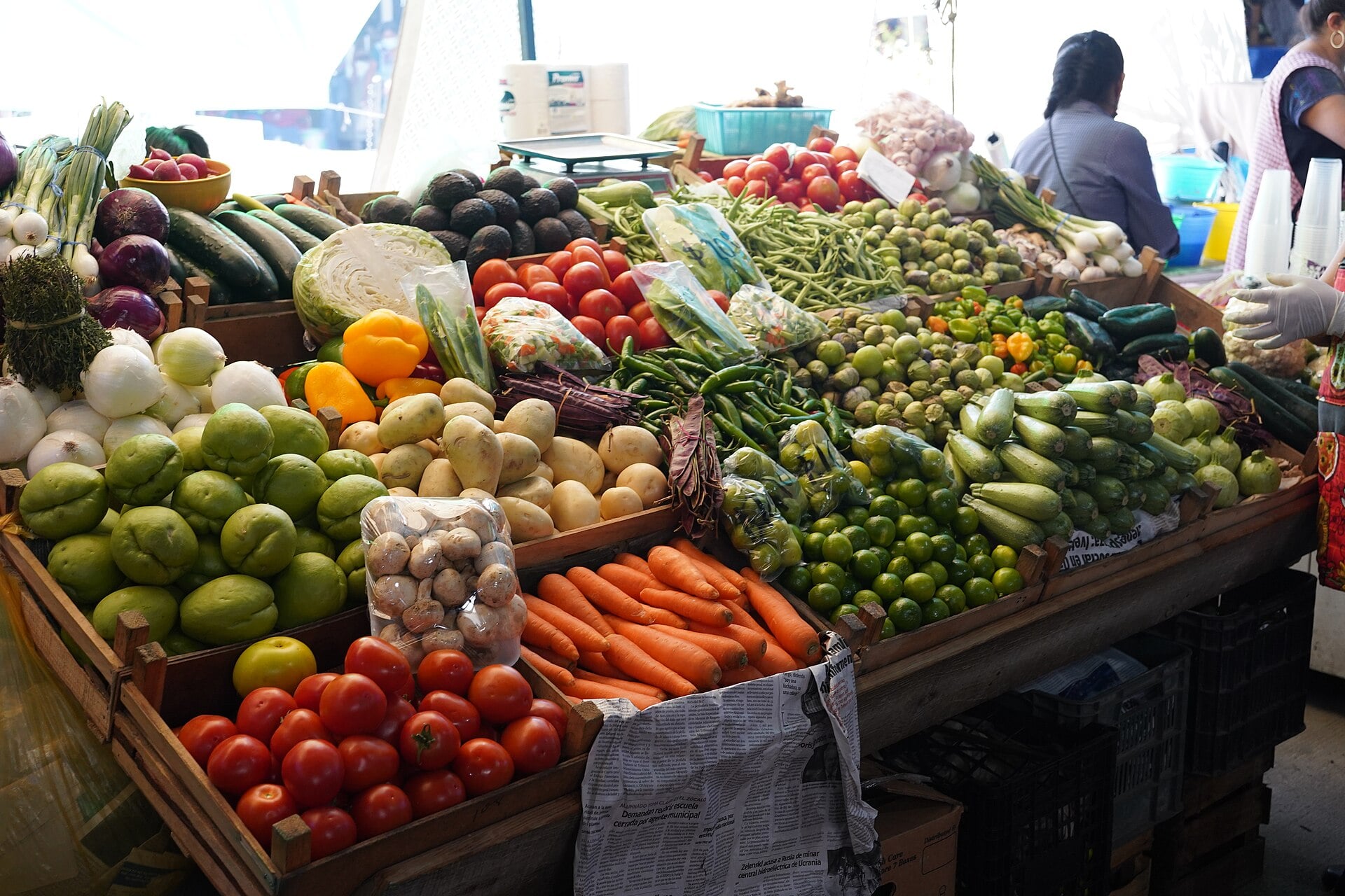 Vendors and shoppers among stalls of produce at the Tlacolula market in Oaxaca, Mexico