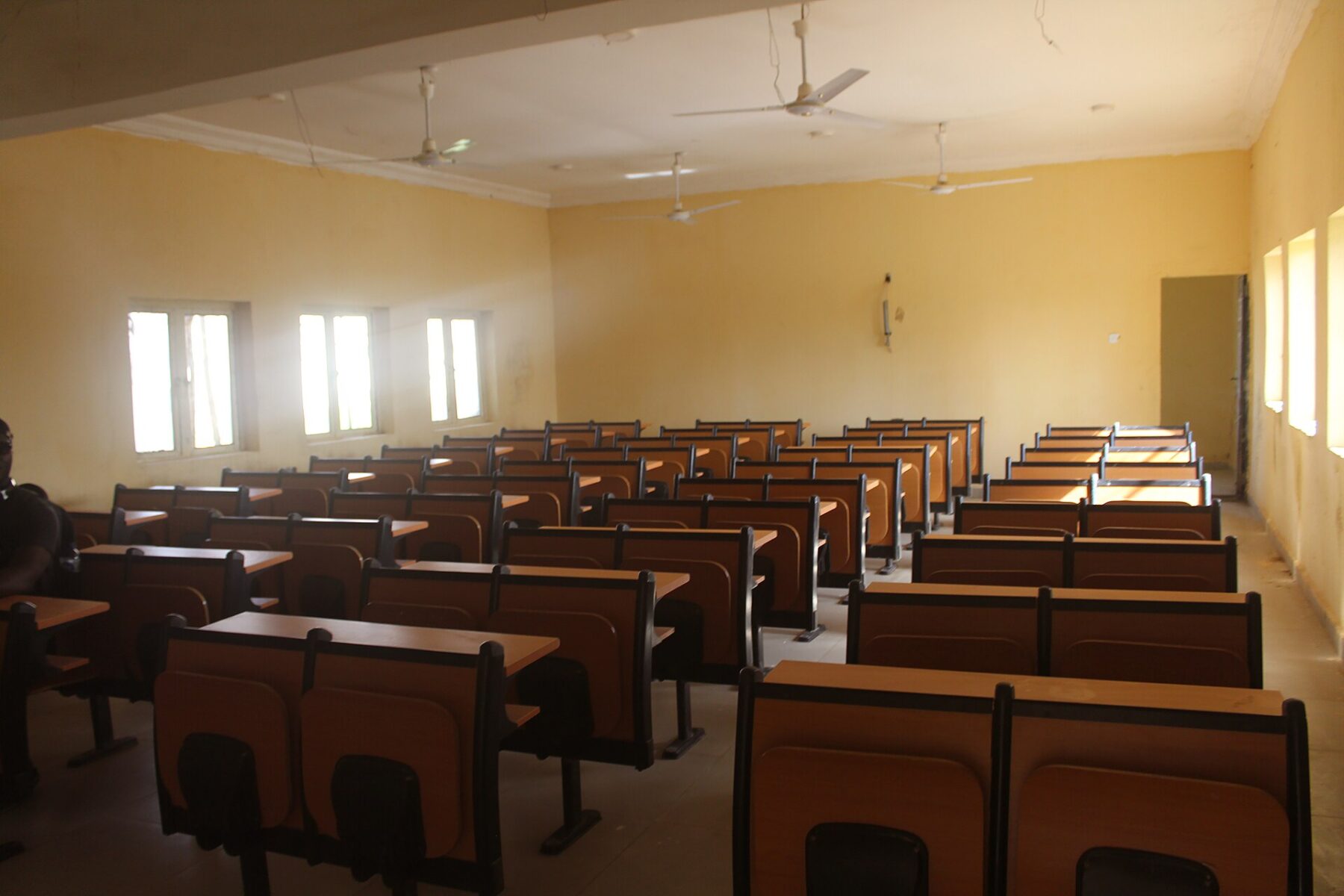 An empty classroom with rows of wooden desks