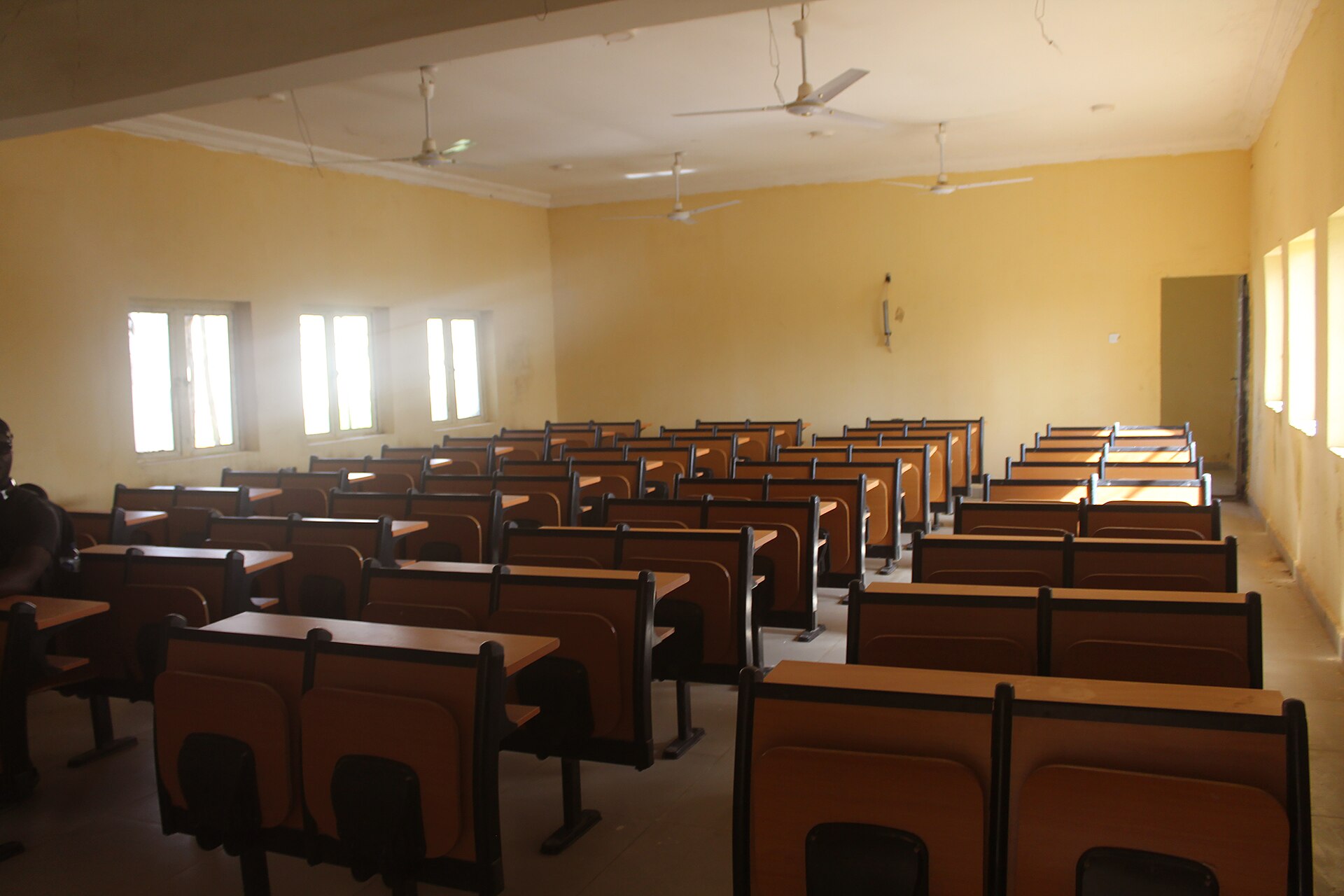 An empty classroom with rows of wooden desks