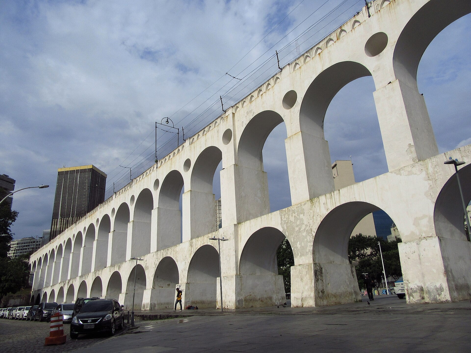 The white arches of the Lapa aqueduct in central Rio de Janeiro under a partly clouded sky