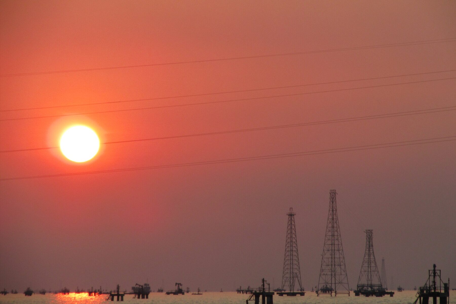 Oil rigs and sunset over water