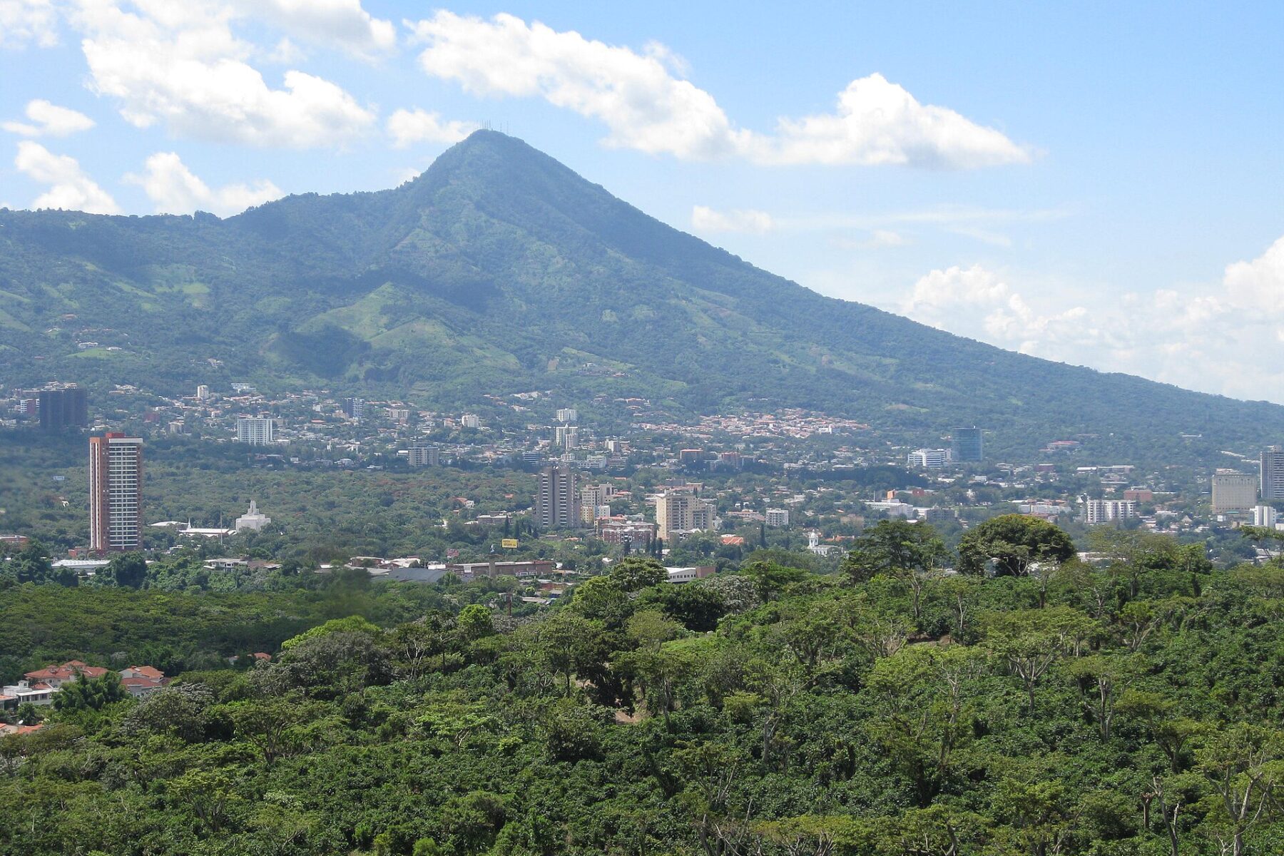 Investing in El Salvador 2026 — San Salvador high-rises below the San Salvador volcano