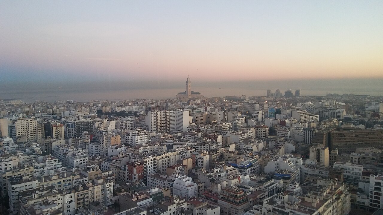 Casablanca at dawn from above, with the minaret of the Hassan II Mosque on the coast
