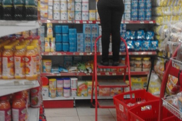 Supermarket worker restocking shelves in Ketu, Lagos