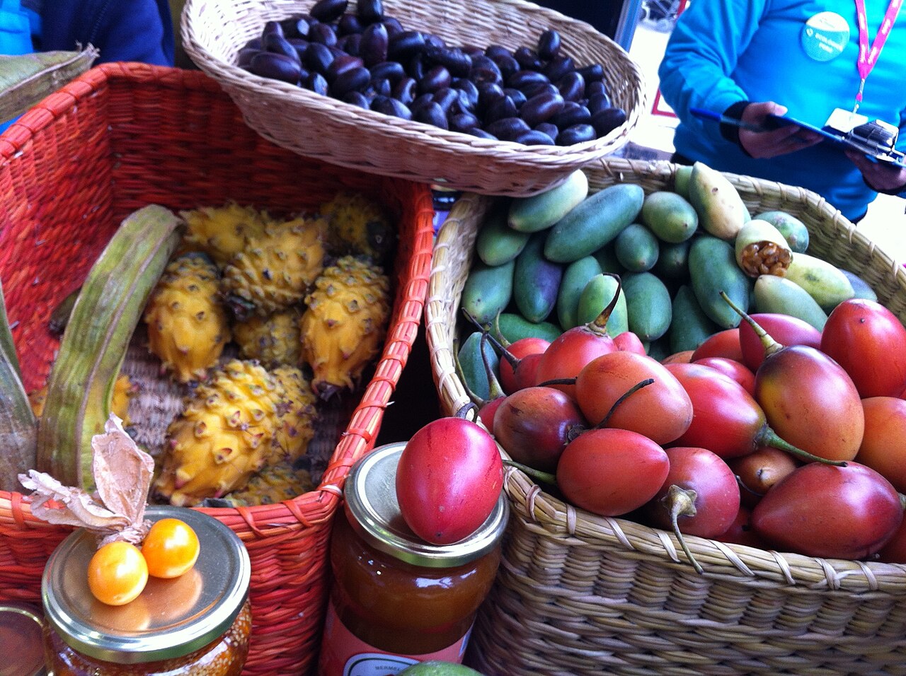 Baskets of native Peruvian fruits, including pitahaya and tomate de arbol, displayed at a Lima food fair.