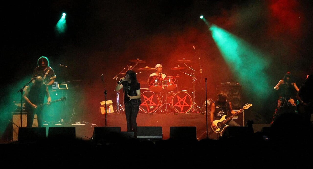 Mägo de Oz playing on a red-lit stage in Spain, the band behind the Mägo de Oz Mexico City concert