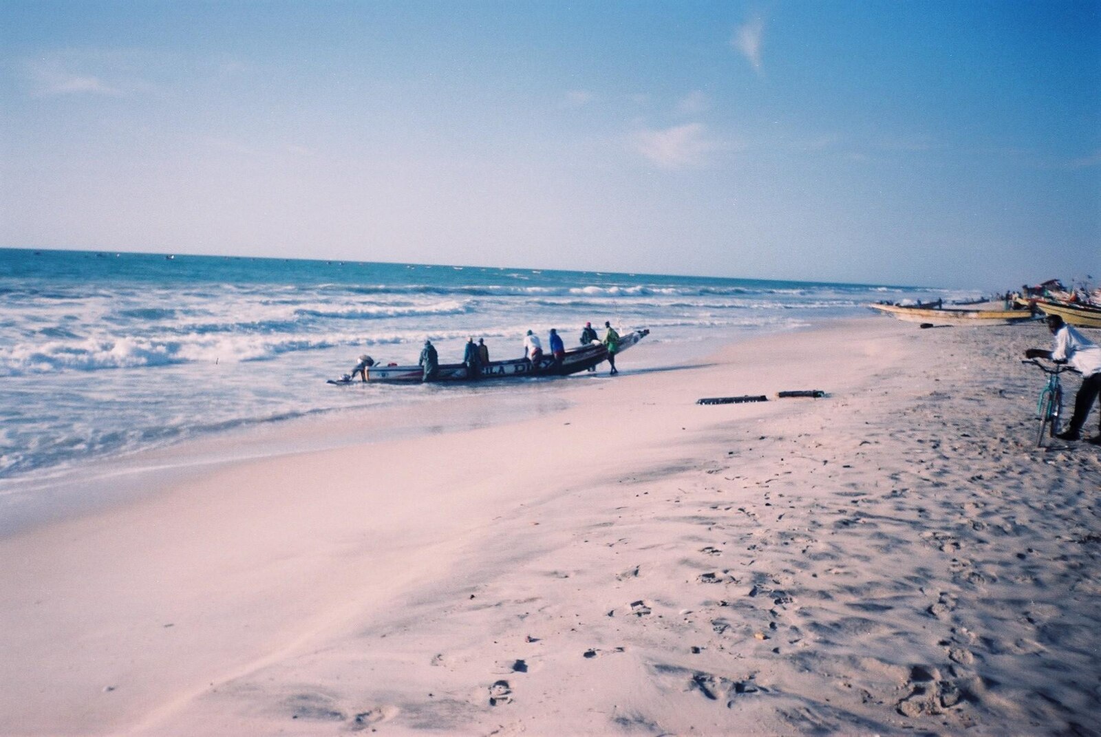 Mauritania explained: fishermen haul a wooden boat onto the beach at Nouakchott