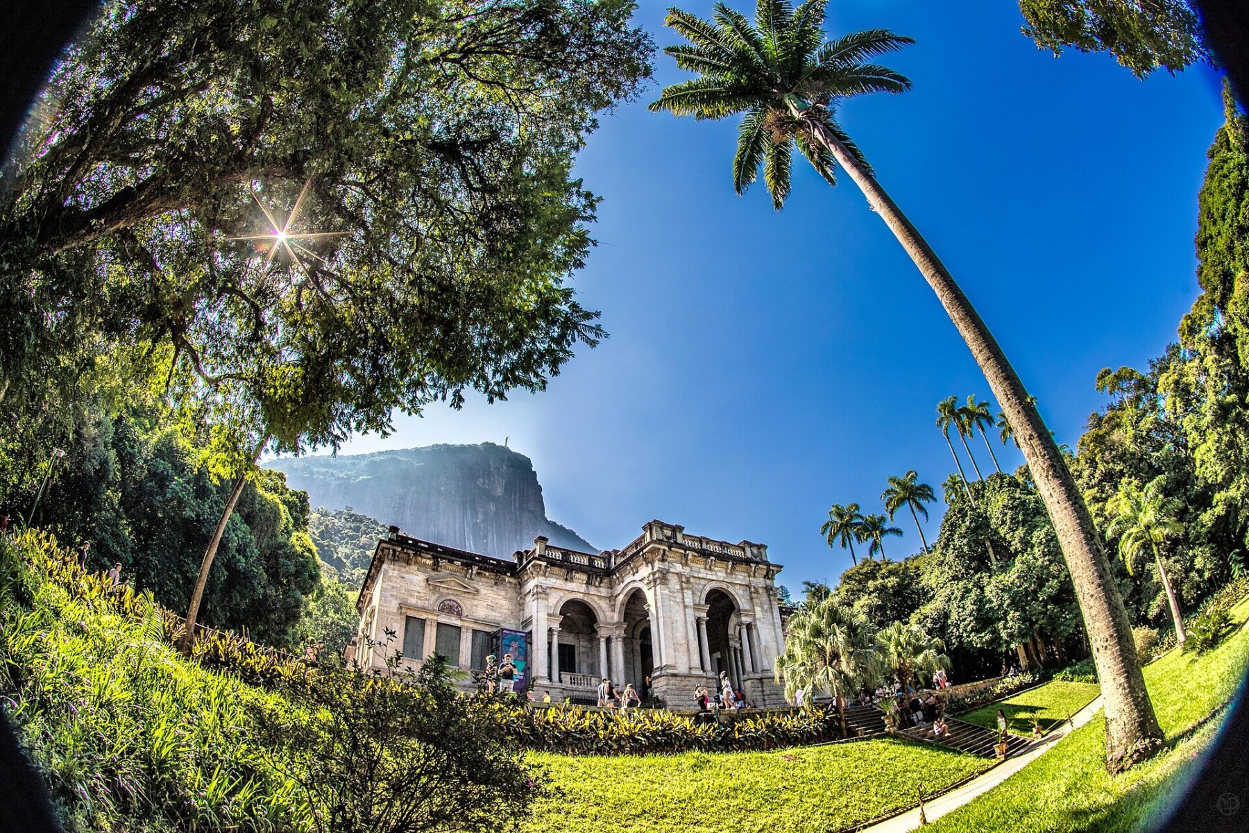 The palace at Parque Lage in Rio de Janeiro under a clear blue sky, with Corcovado and the Christ the Redeemer statue behind