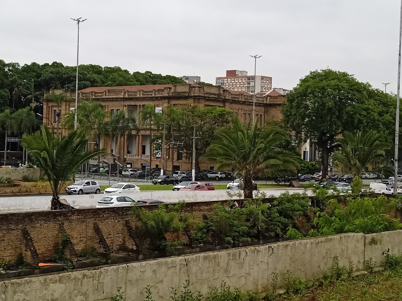 Exterior of the Pinacoteca do Estado de Sao Paulo museum building, seen through palm trees.