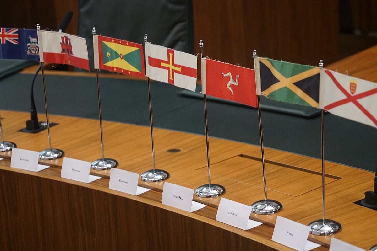 Table flags including Jamaica's inside the Judicial Committee of the Privy Council chamber in London, with printed name cards