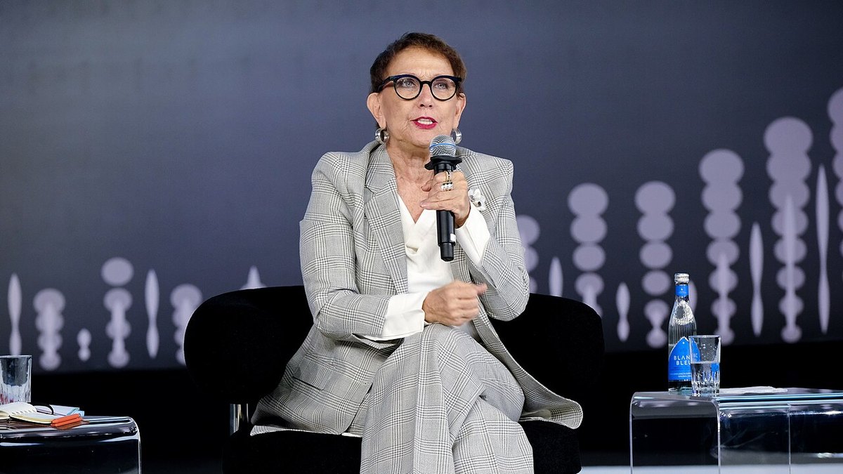 Rebeca Grynspan speaking on stage with a microphone