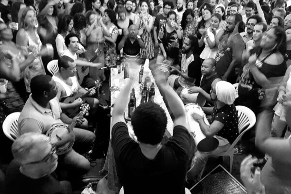 Rio de Janeiro nightlife: musicians play a samba roda around a table, surrounded by a dancing crowd