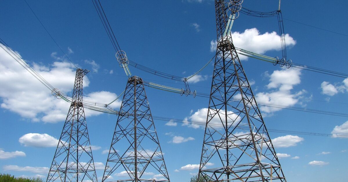 High-voltage transmission pylons under a blue sky