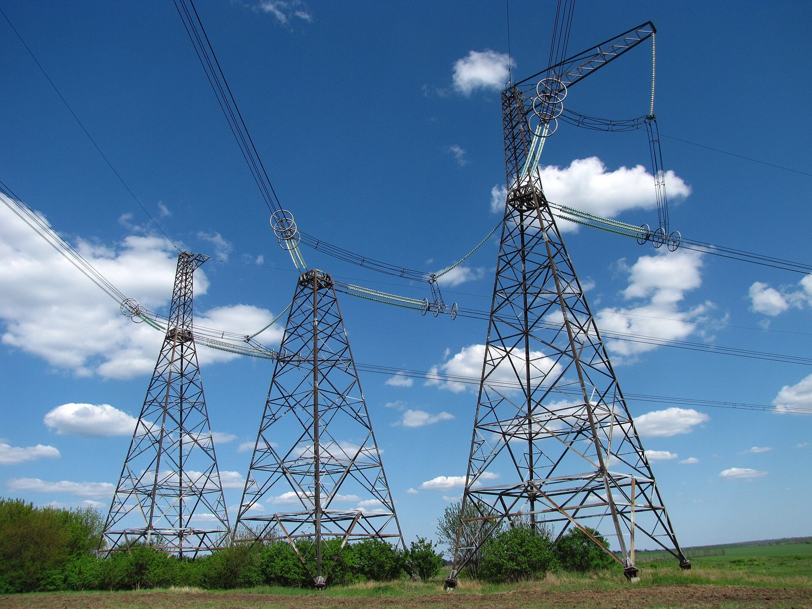 High-voltage transmission pylons under a blue sky