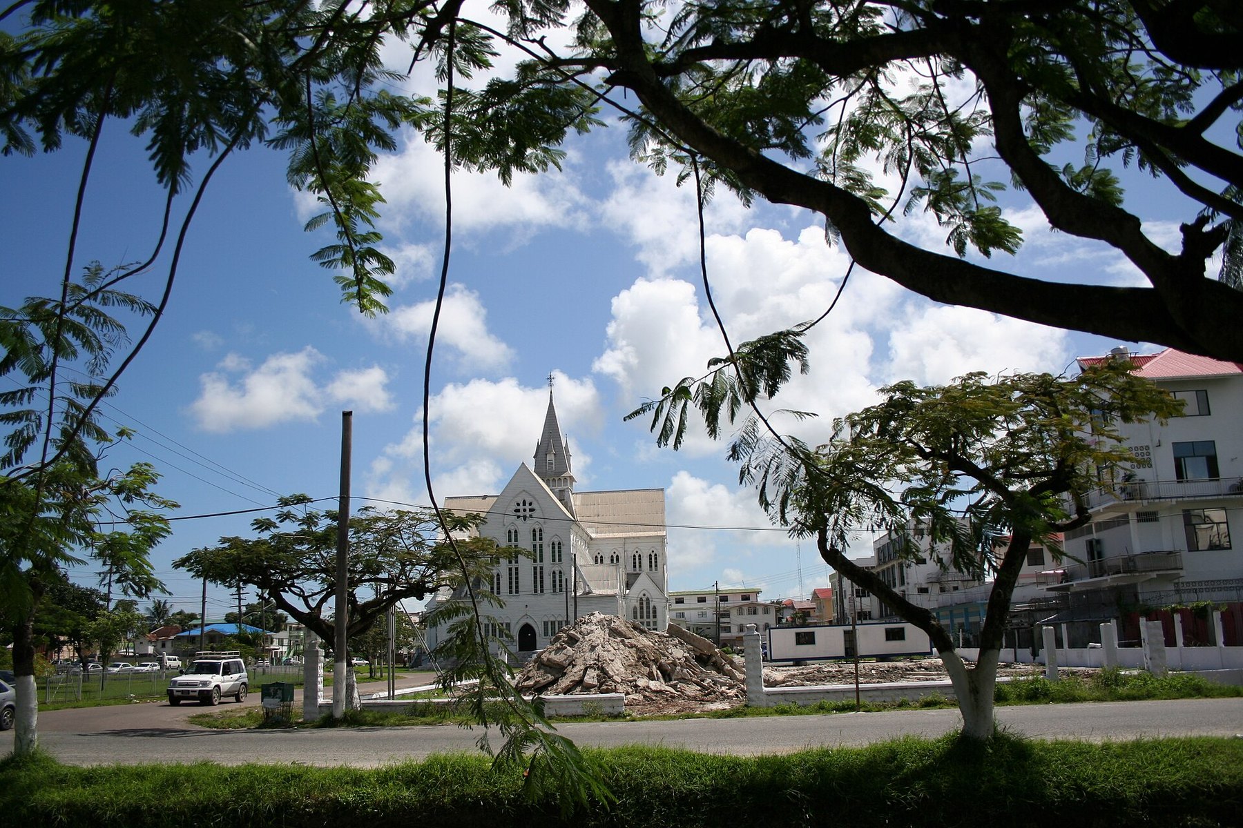 A street in Georgetown, Guyana, with St George's Cathedral behind trees