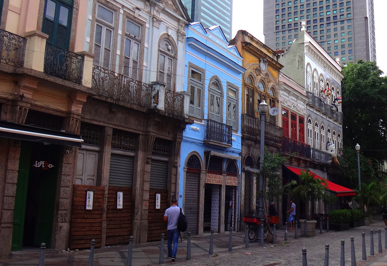 Row of colourful nineteenth-century townhouses with iron balconies on the cobbled Rua do Lavradio in central Rio de Janeiro by day, office towers behind