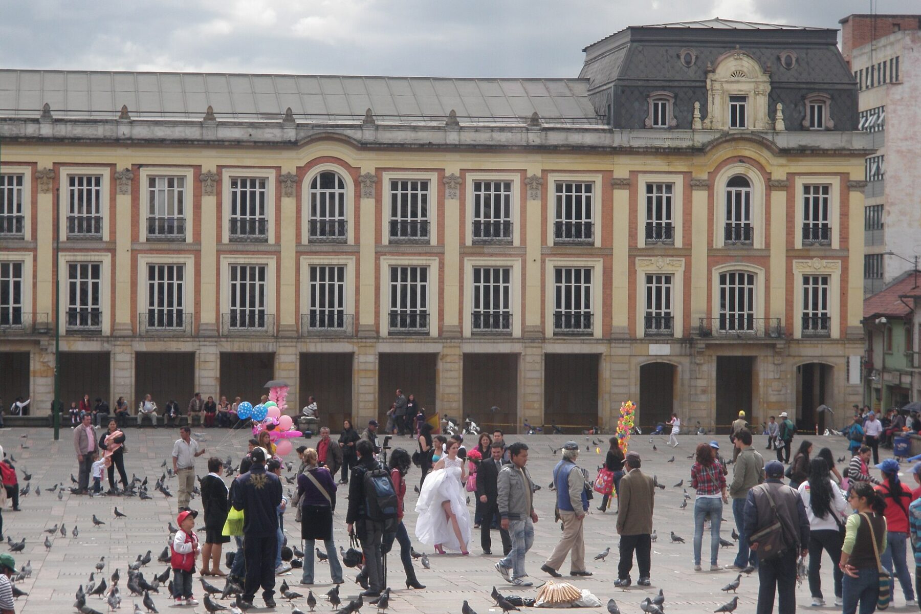 Palacio Liévano, the yellow-and-brick seat of Bogotá's mayor's office, seen across Plaza de Bolívar with people and pigeons