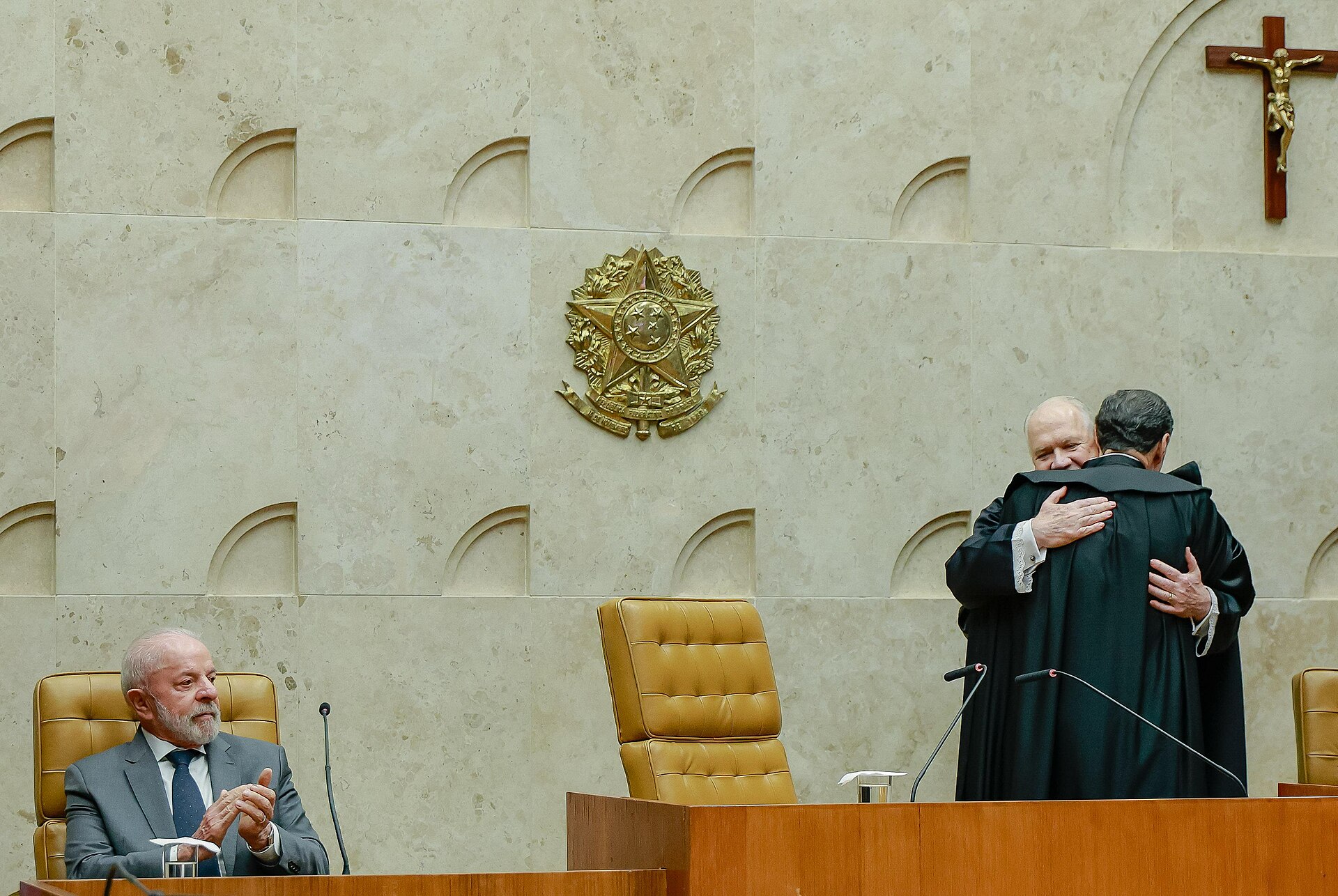 Edson Fachin embraces Alexandre de Moraes in the Supreme Court chamber as President Lula applauds